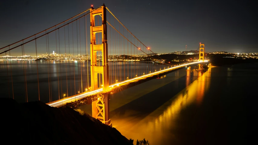 a large bridge spans across the water into a city