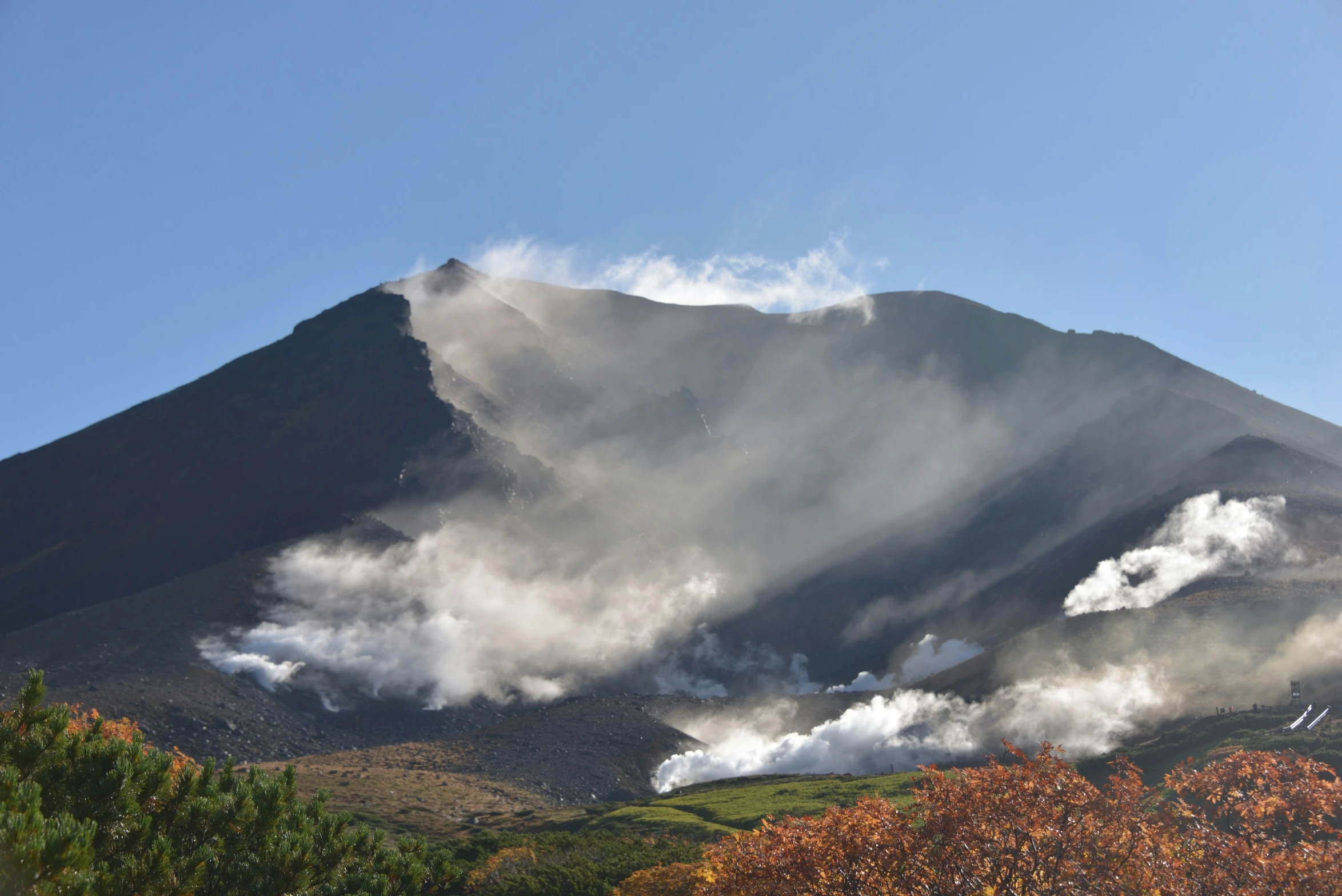 a mountain covered in mist and clouds in the distance