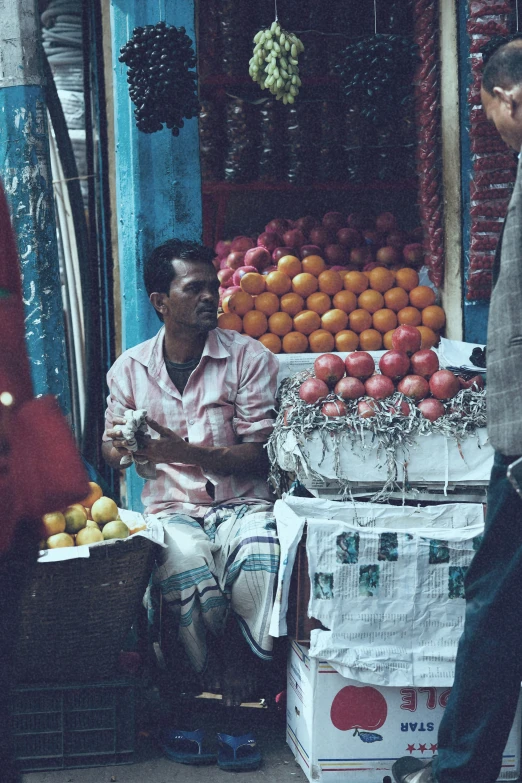 two men sitting on the side of the road, one of them talking