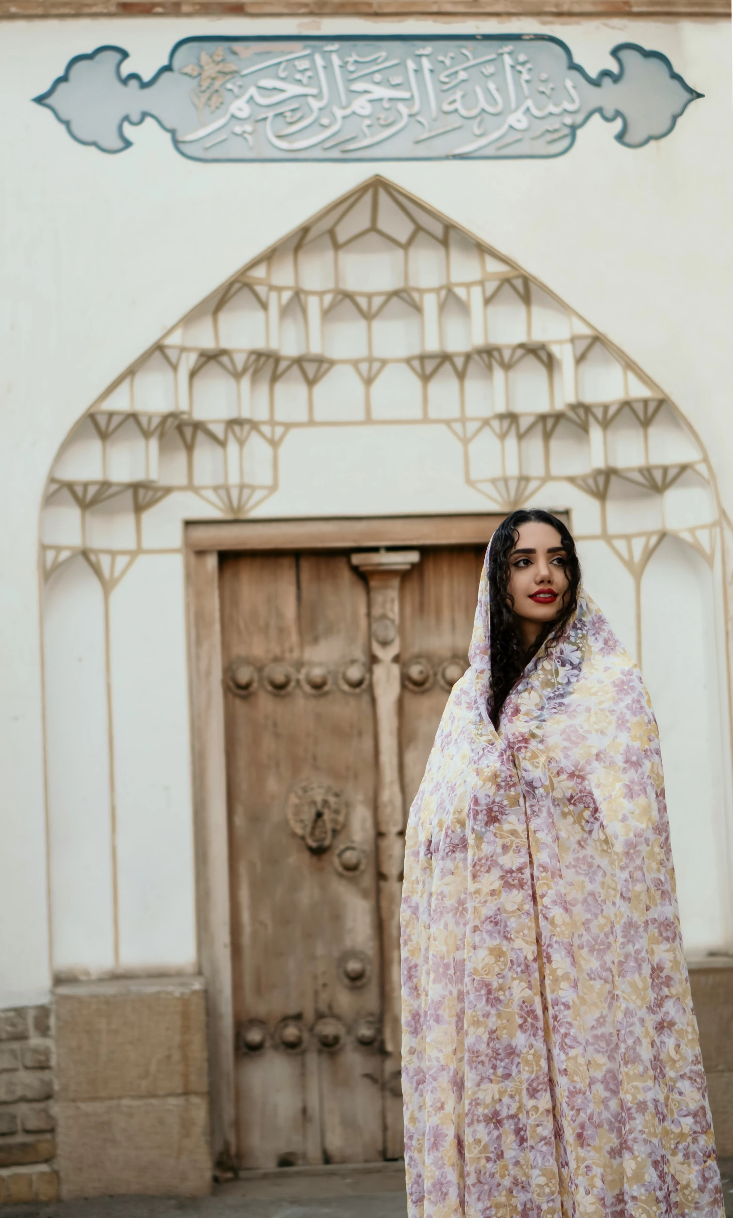 a woman is standing under a floral veil