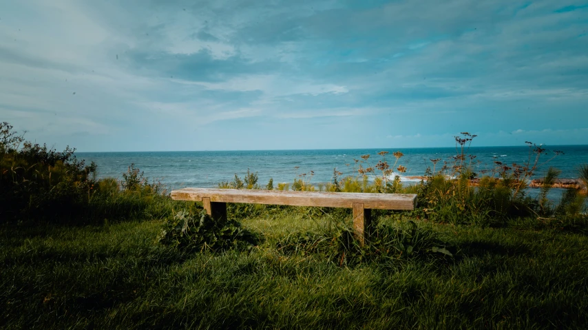 a bench is sitting on the shore line