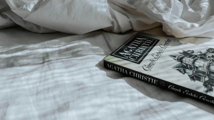 a book laying on top of a bed with sheets