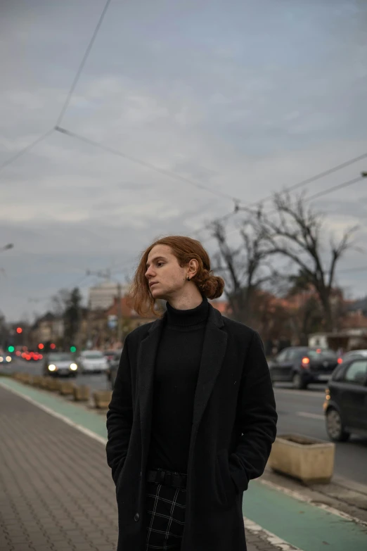 a woman is standing in front of a paved road