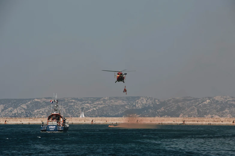 an aircraft flying low above a boat on the water