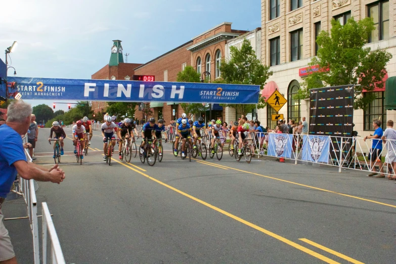 several bicyclists ride under a finish line