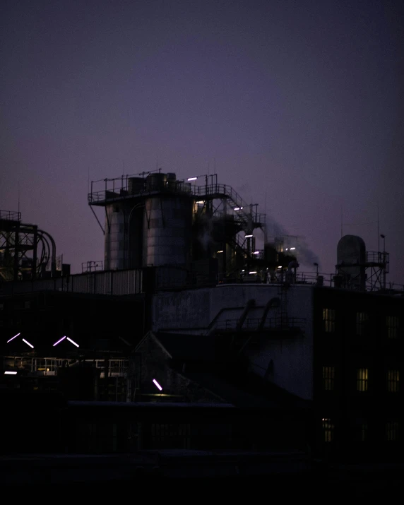 a large industrial factory with lights on