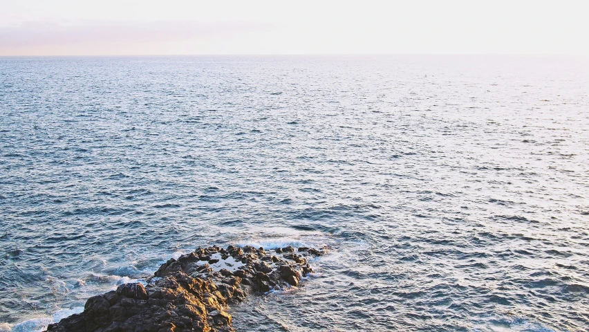 a po of the ocean from an incline above the water