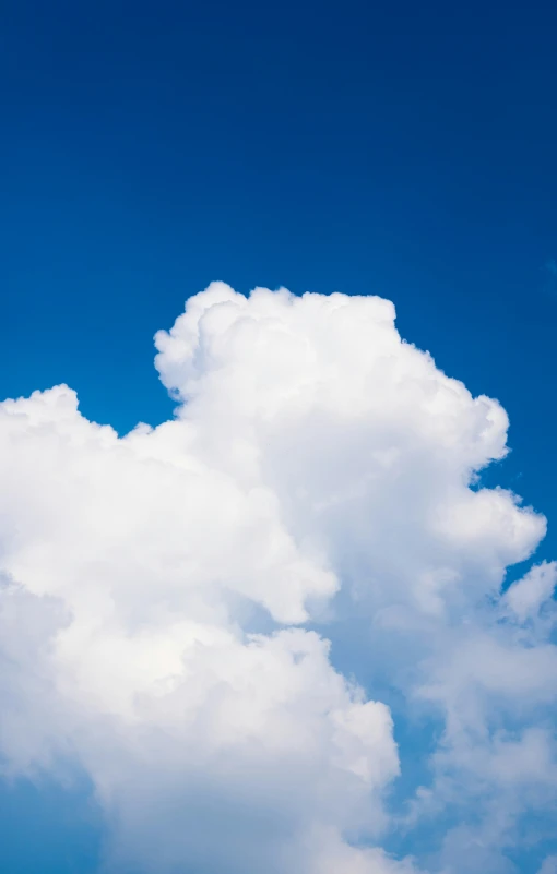 an airplane flying high in the sky with large clouds above it