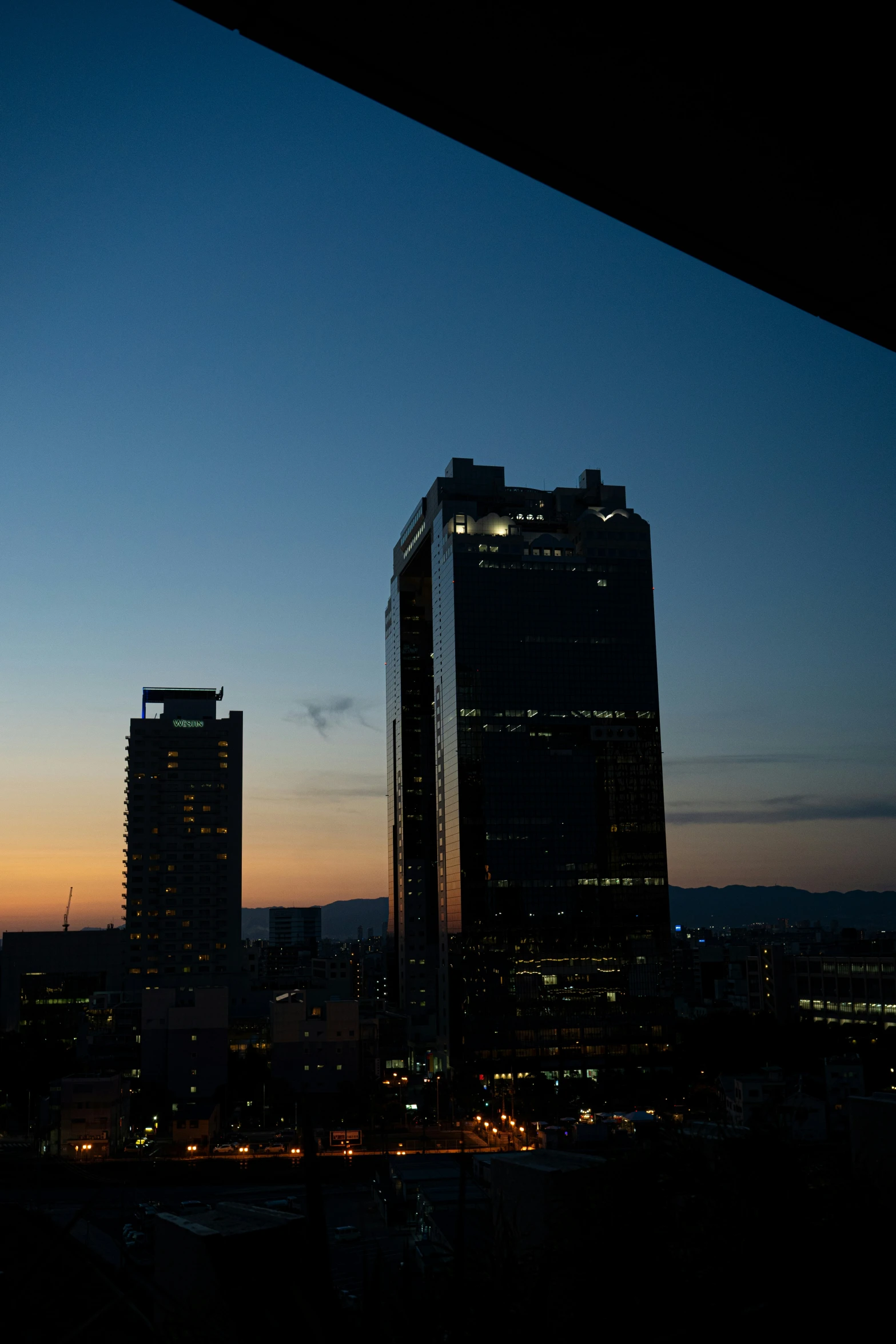 a cityscape at night with buildings silhouetted in the background