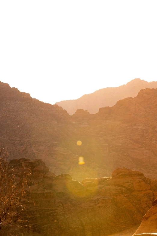 the mountain range in the distance with the sun shining through the mountains