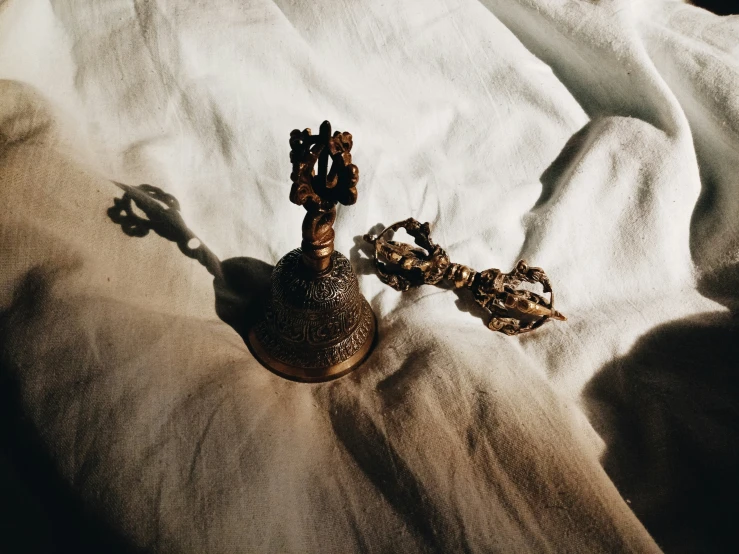 a tiny vase with a chain resting on a blanket