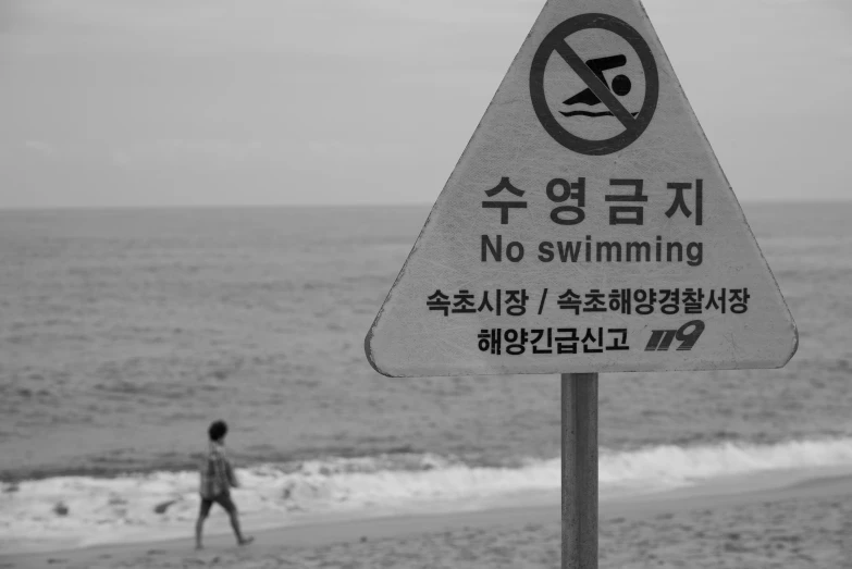 there is a warning sign posted on the beach