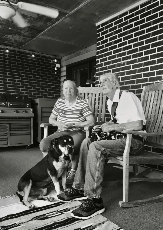 two elderly people and their dog on a porch
