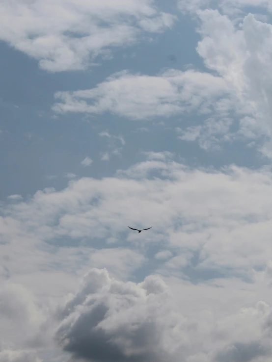 a large airplane flying high in the cloudy sky