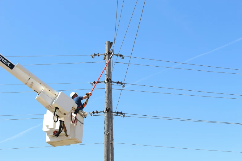 man standing on power line and repairing electrical wires