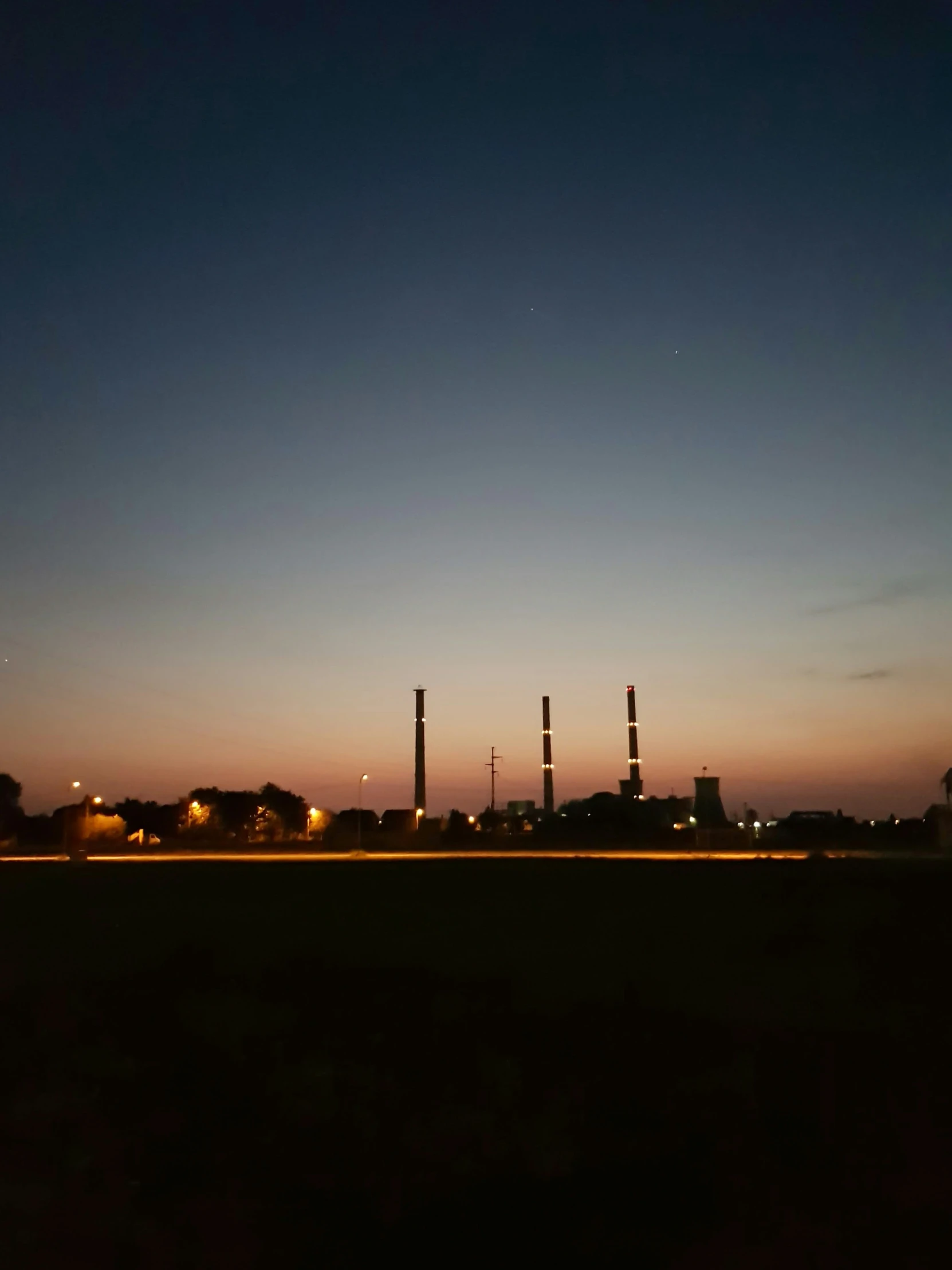 night time view of a factory area and trees