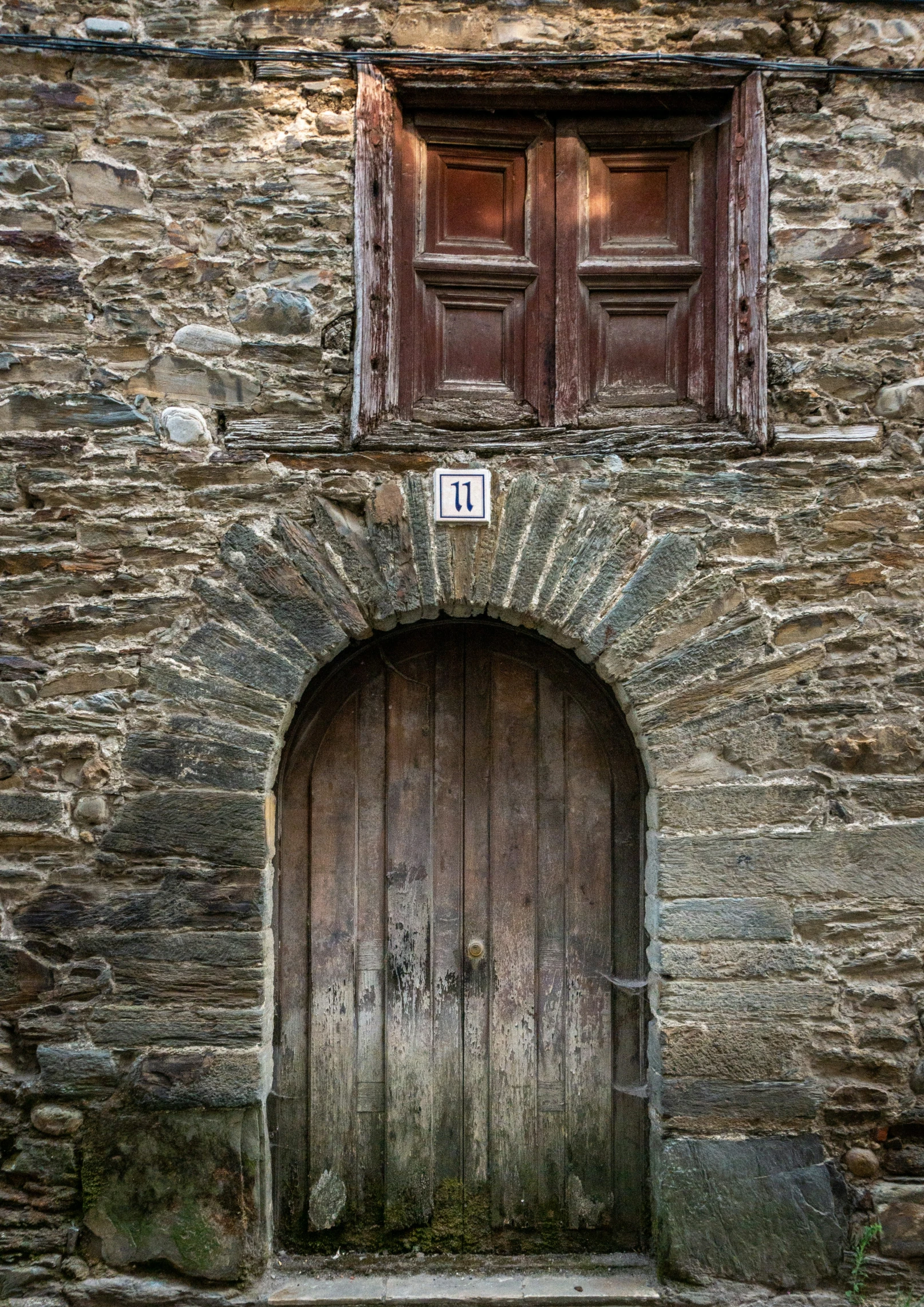 a wooden door on the side of an old stone building