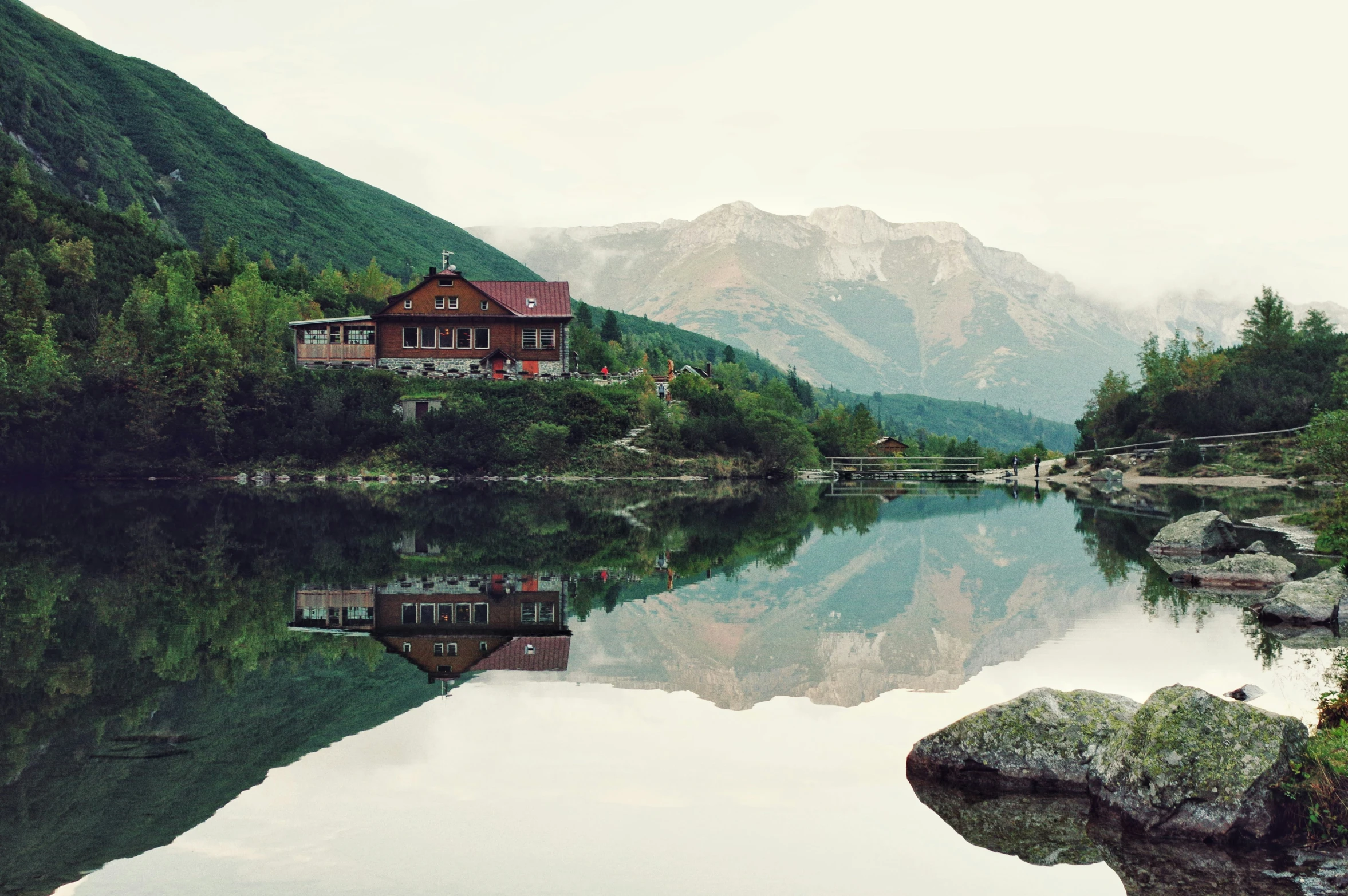 a house on a mountain lake surrounded by trees