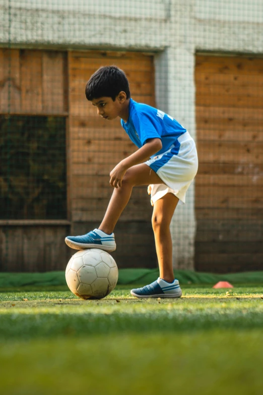 a  kicking a soccer ball on a field