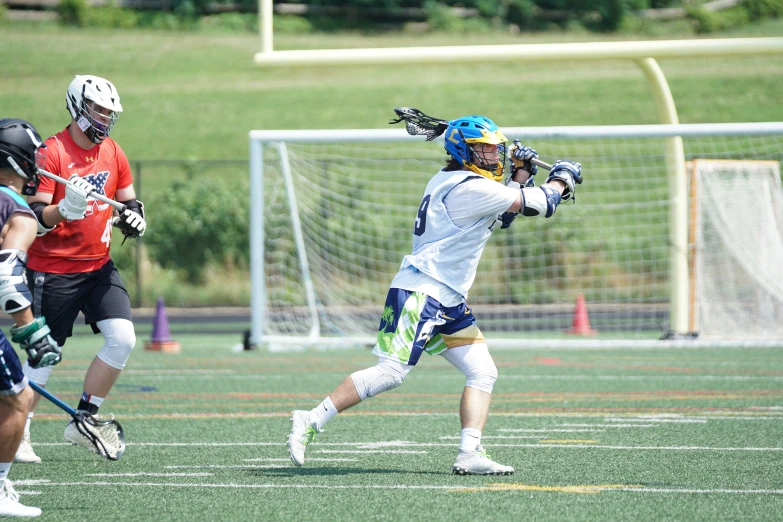 a lacrosse player has hit the ball, while the other players look on