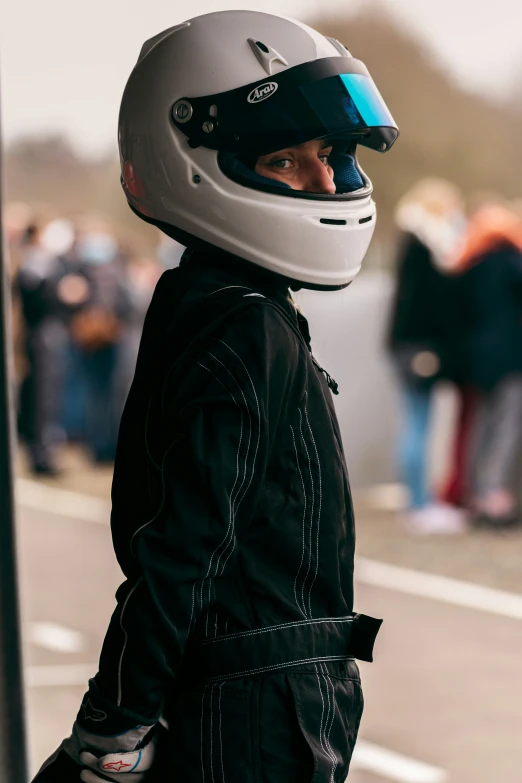 the man is wearing a helmet as he stands by a pole