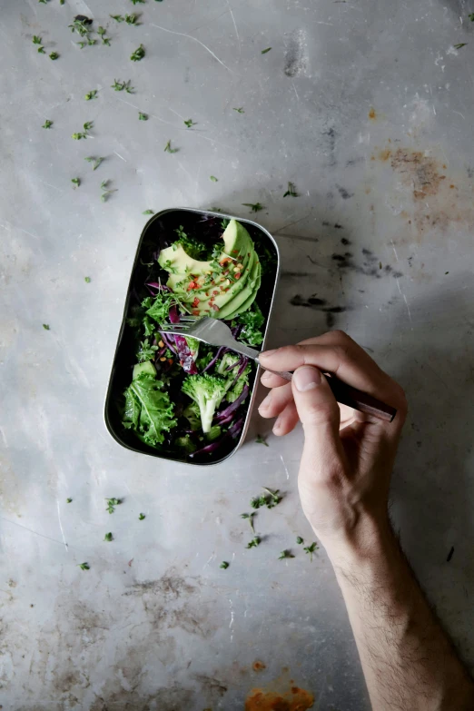 person taking a spoonful of food out of a container