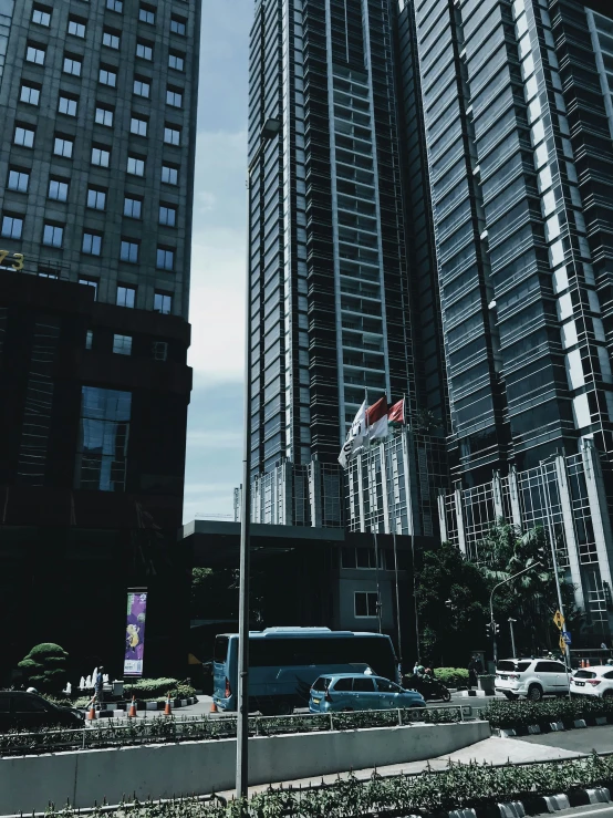 two large buildings in a city with flags