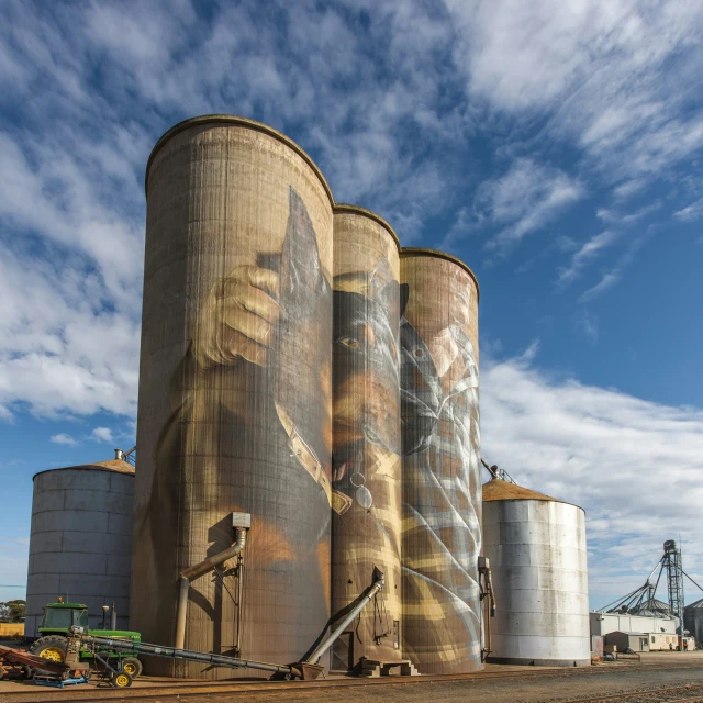 a large grain silo sitting on top of a dirt field