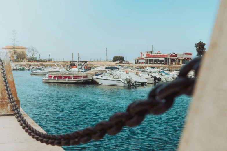 several boats parked in the water by a pier