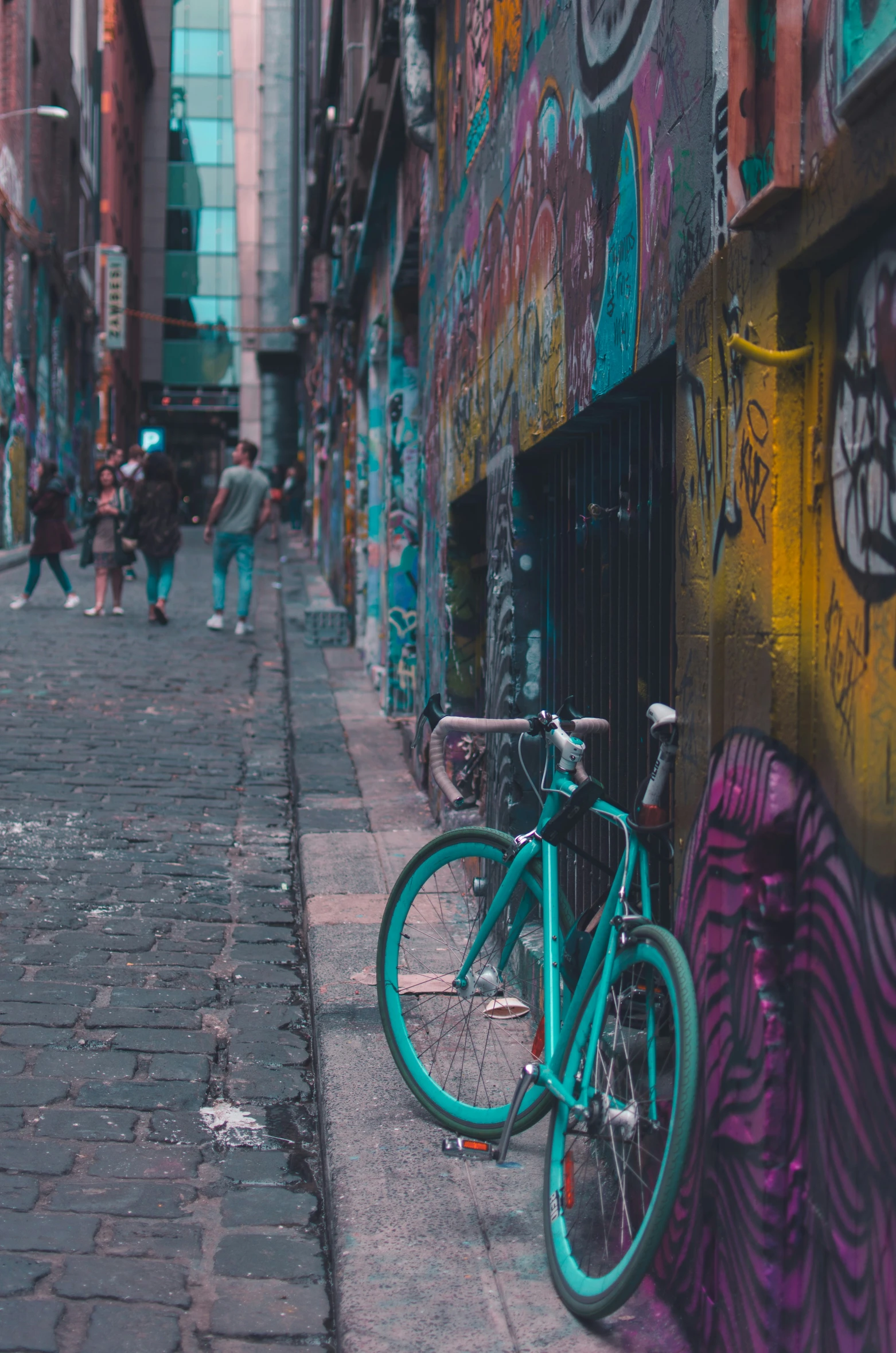 a colorful wall covered in graffiti, with a bicycle parked next to it