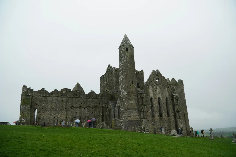 people standing outside a large stone castle type structure