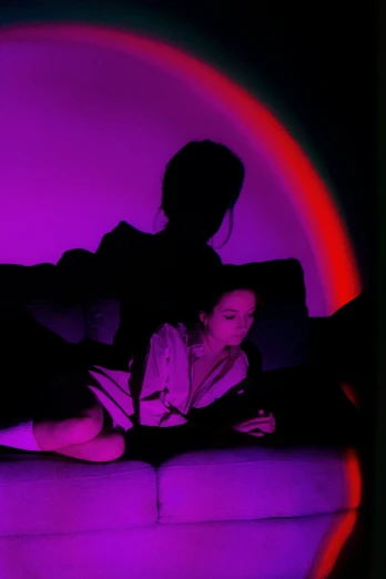 a person laying in bed under purple lighting