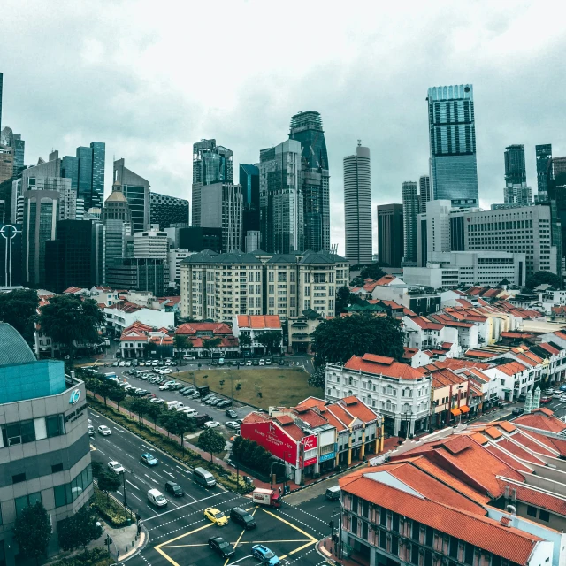 a city with tall buildings in the background and a red roof