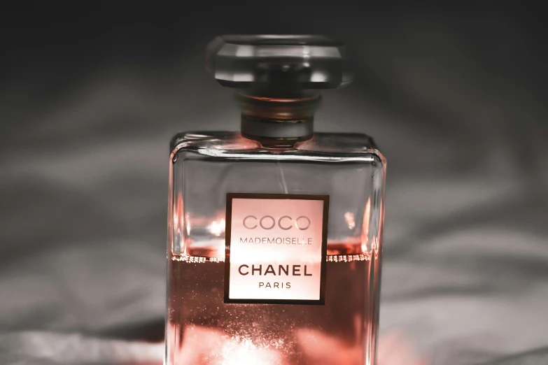 a bottle of perfume sitting on top of a bed