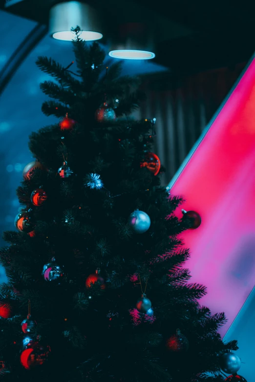 a black christmas tree with ornaments lit up