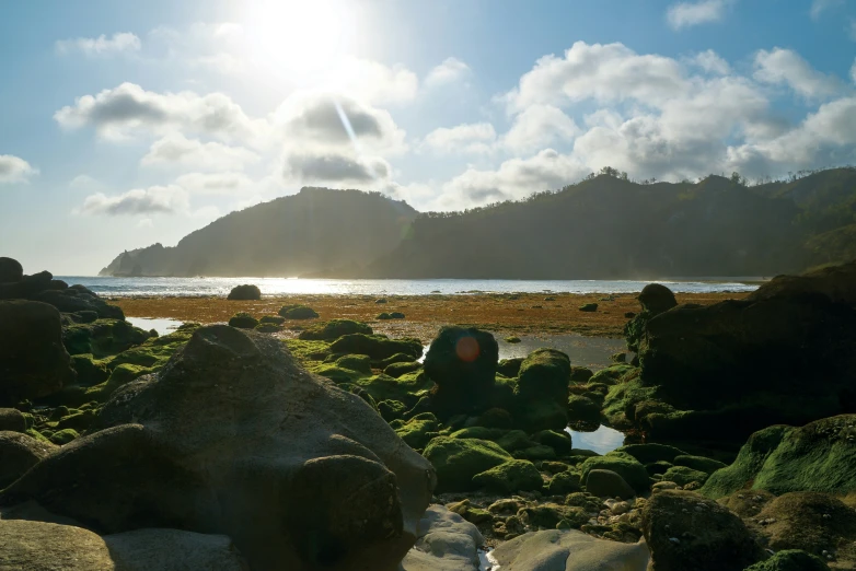 two people sitting on rocks next to a body of water