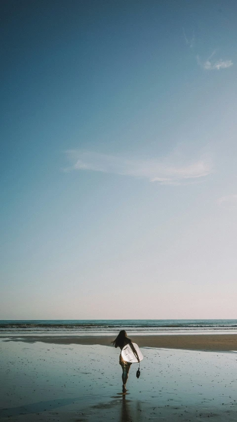 a man running into the ocean with his surf board