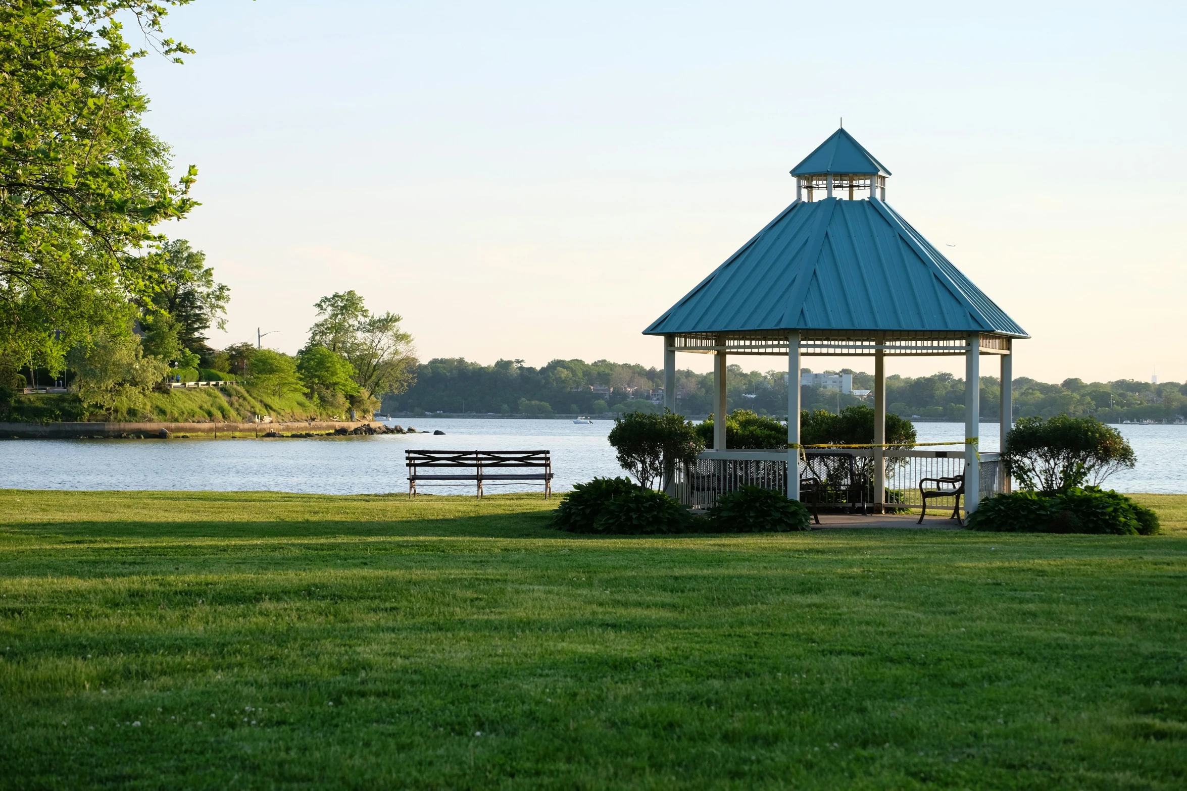 park view of a gazebo with park benches near the water