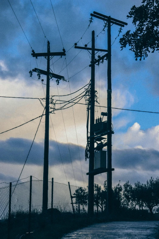telephone poles on a hill in the dusk time