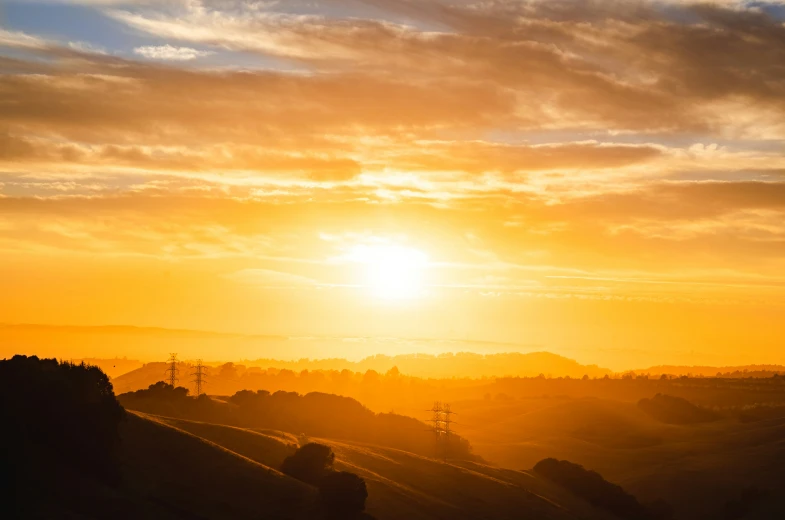 the sun is setting with the light reflecting off the distant