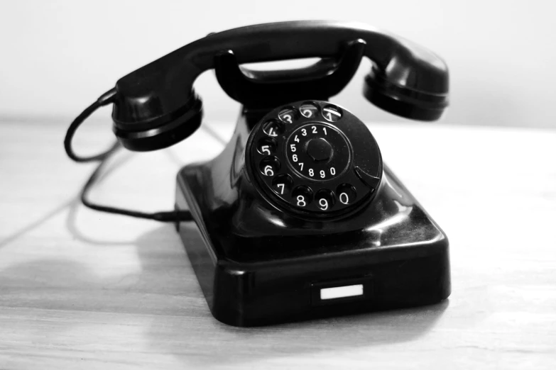 a black telephone on a wooden table