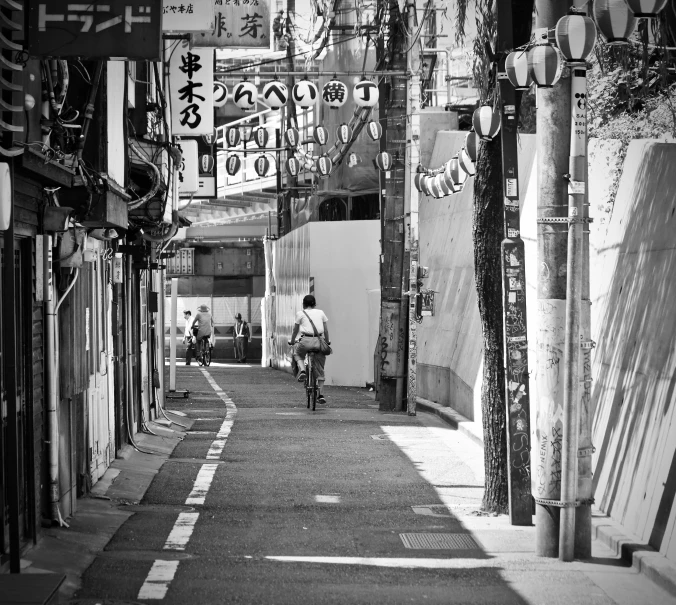a man is riding a bike down a narrow alley