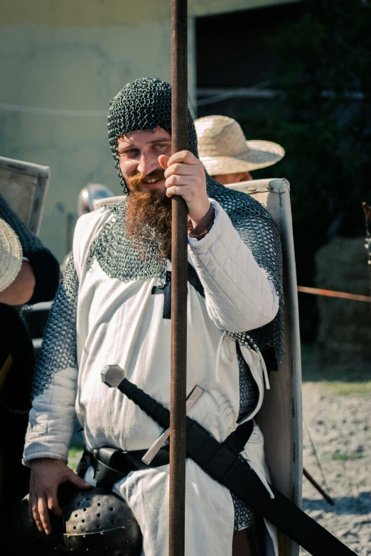 a man in a suit of armor stands on stilts