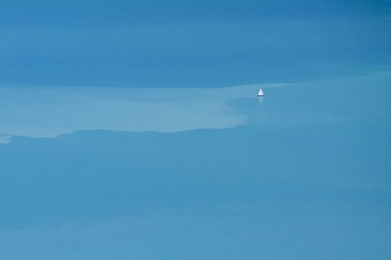 a group of birds flying over a clear blue ocean