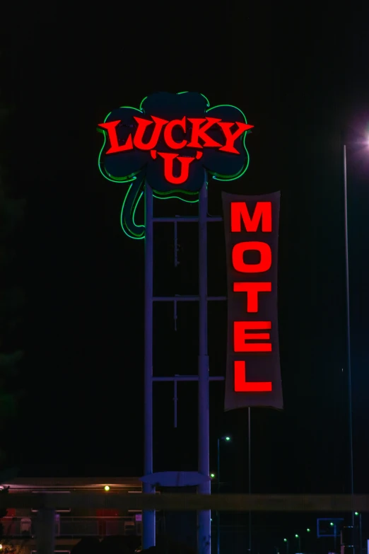 the motel sign is lit up red and green