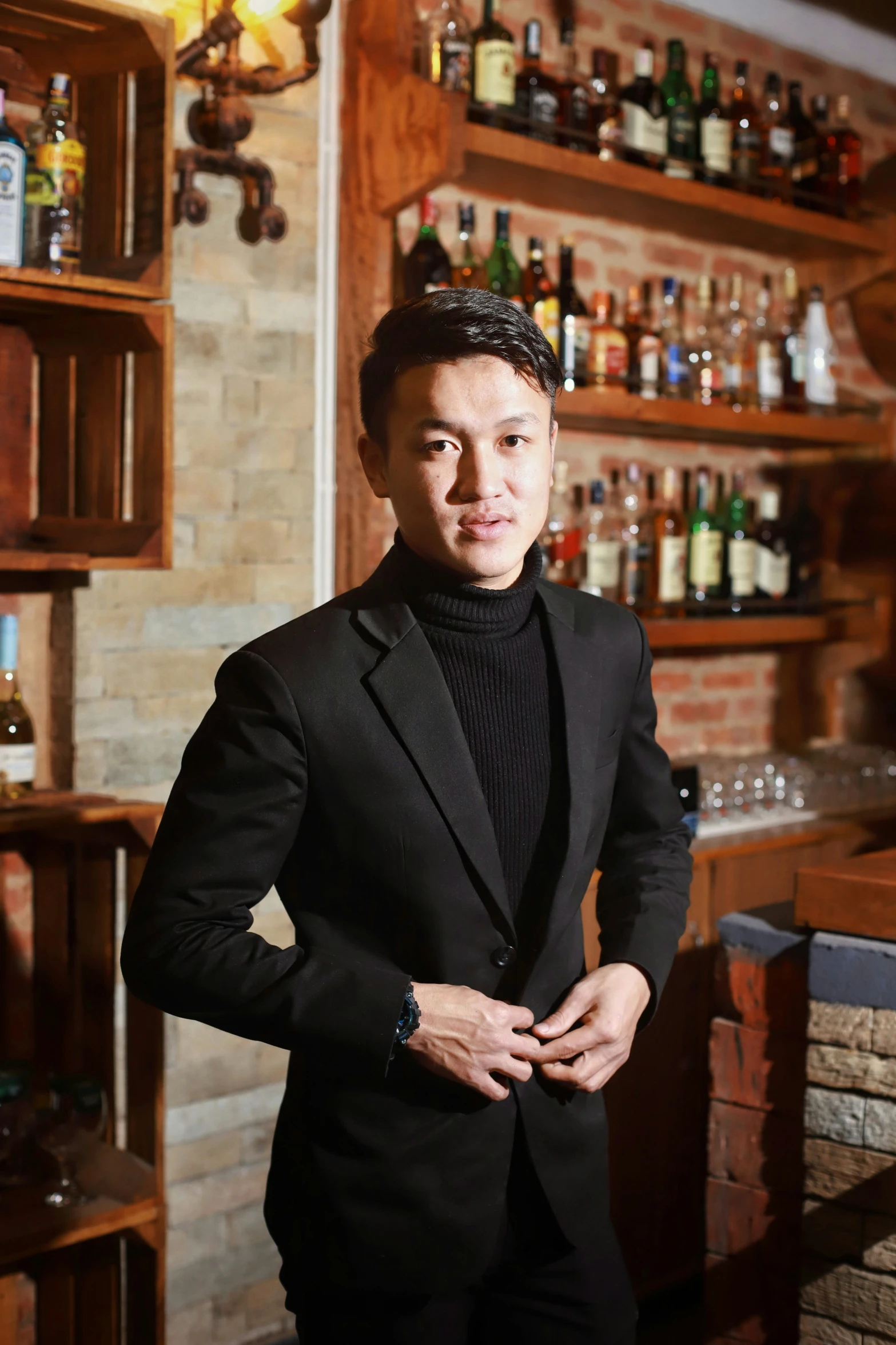 a man standing in front of a shelf full of liquor bottles