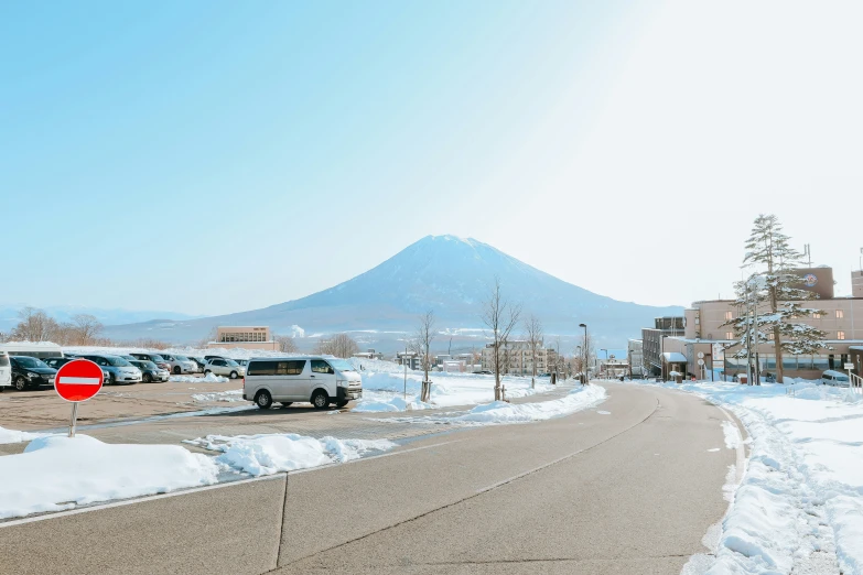 cars parked on the side of the road beside a parking lot