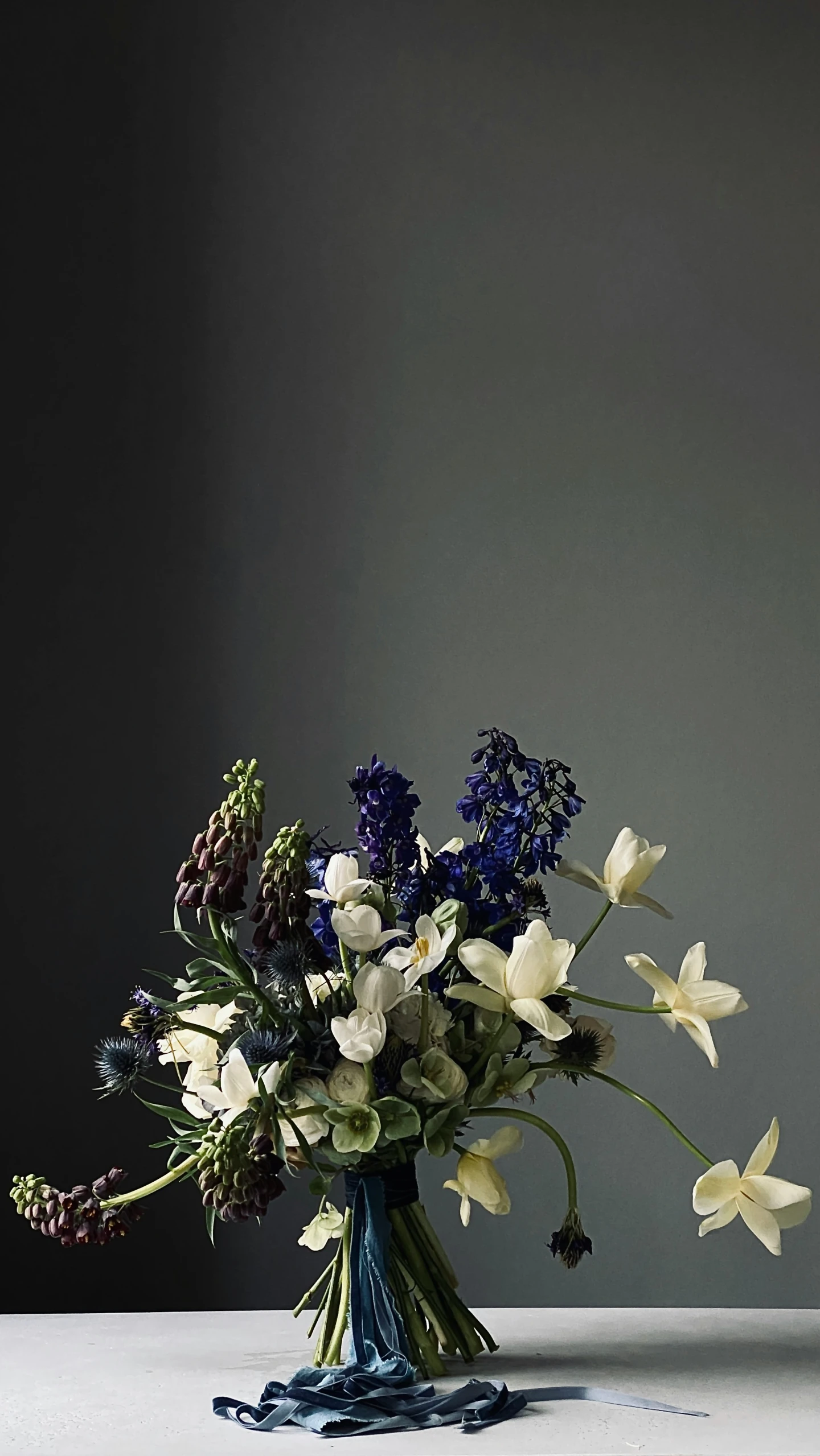 a vase of flowers with greenery sits on a table