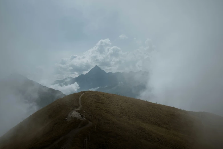 a large grassy hill with a mountain in the background