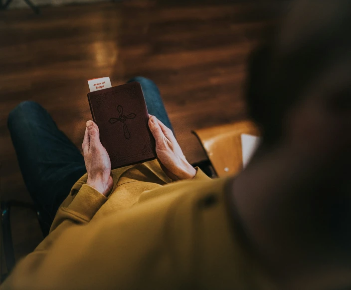 a man laying down while reading the book